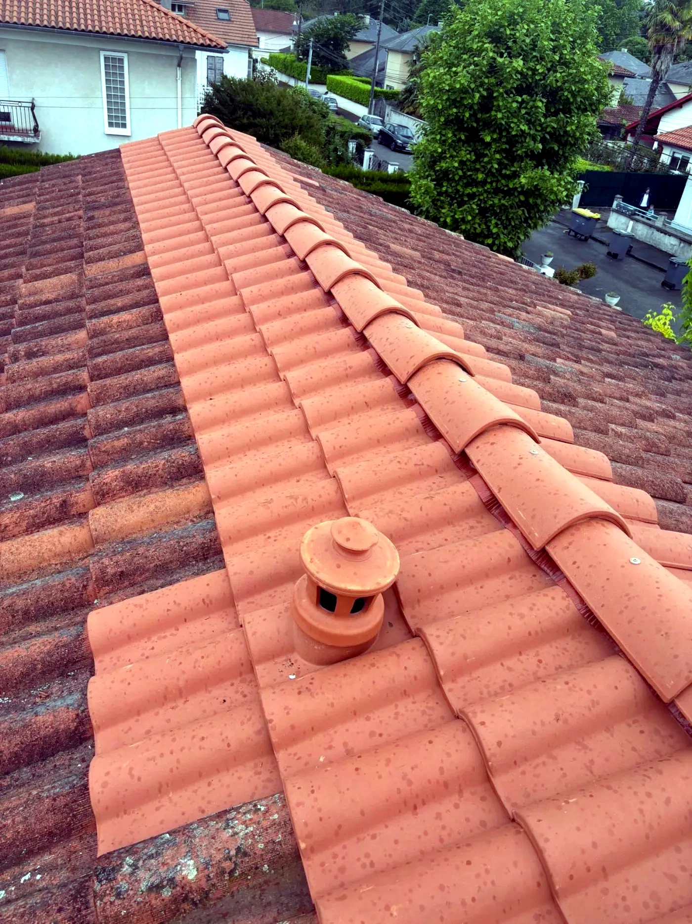 Chatière de ventilation en terre cuite posée sur une couverture en tuiles