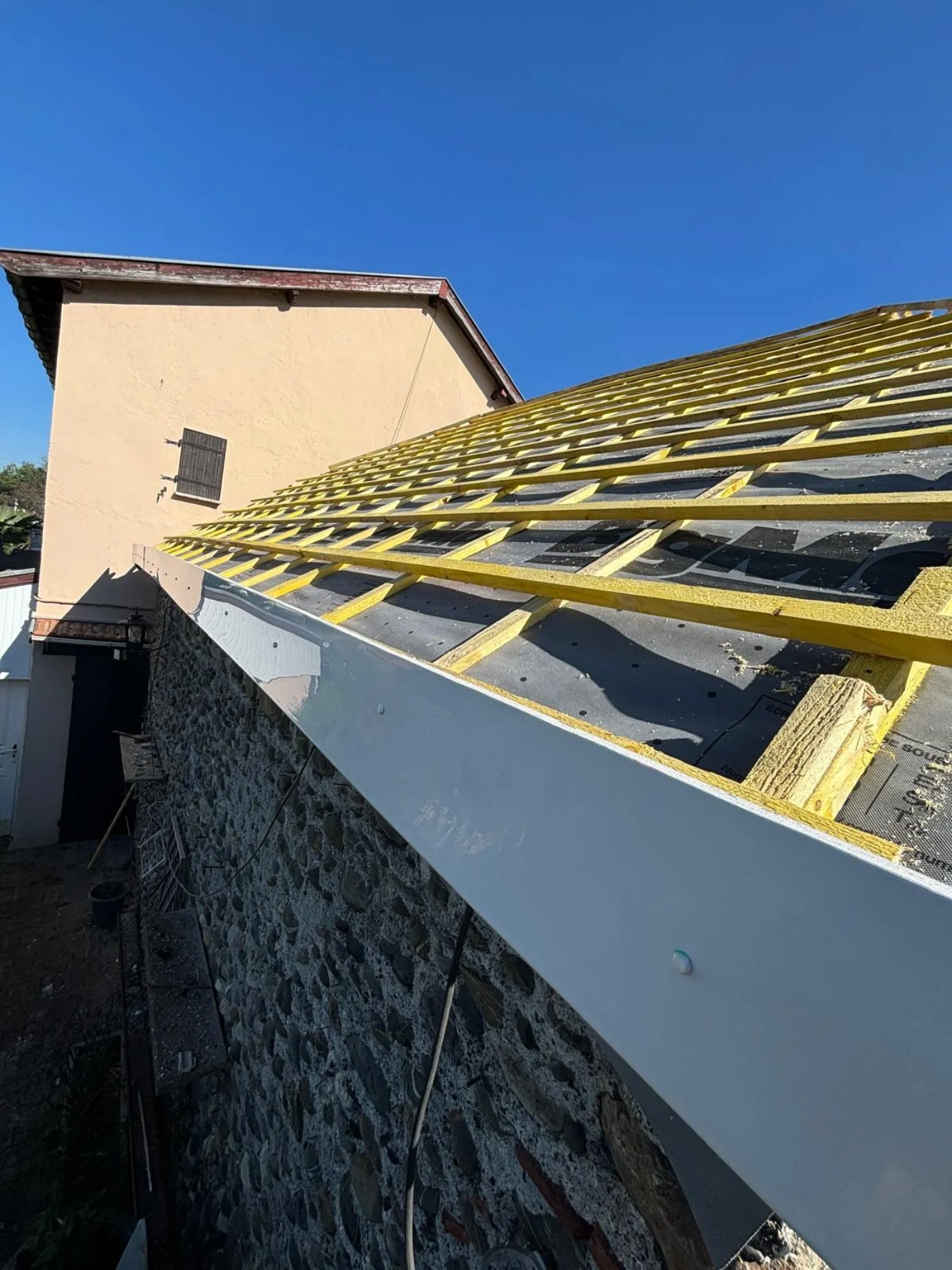 Bavette d'étanchéité en aluminium le long d'un mur en pierre