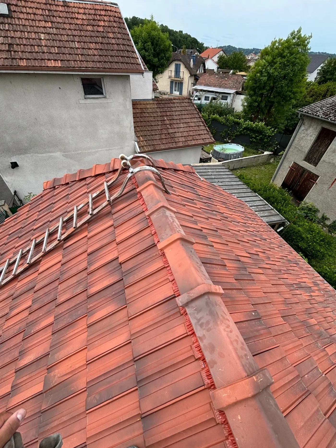 Échelle de toit posée sur une couverture en tuiles en cours de réparation