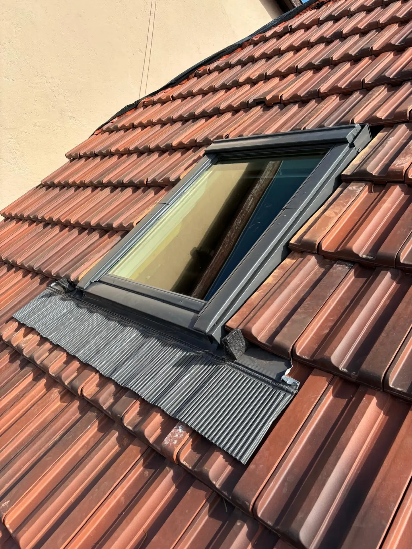Velux neuf posé avec son raccord d'étanchéité sur une couverture en tuiles